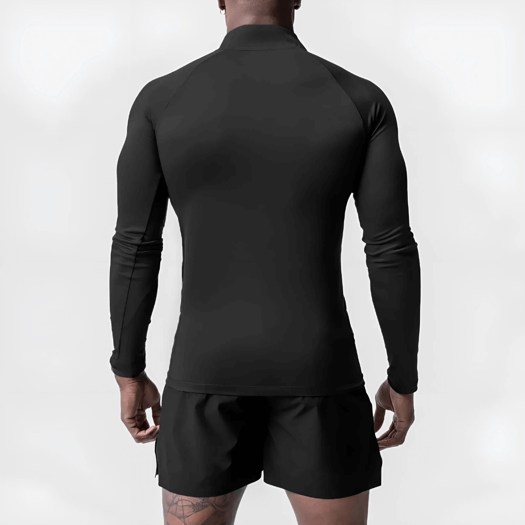 Back view of a man wearing a black Muscle V-Taper Quarter Zip performance top and shorts, showcasing muscular build.