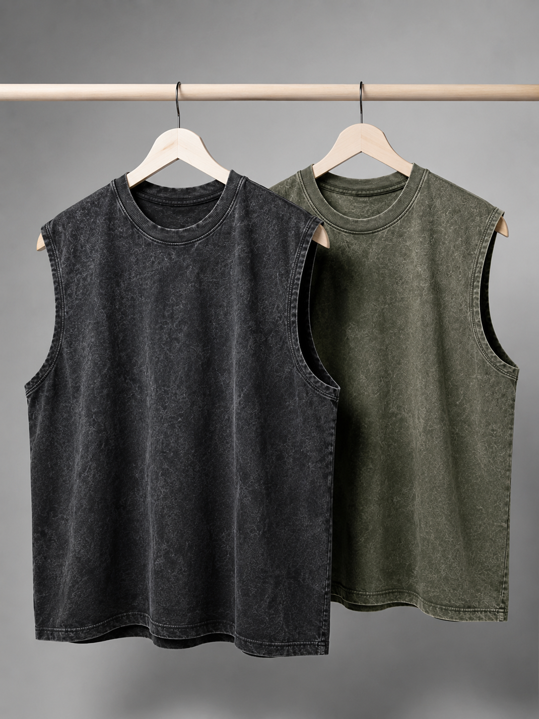 Black and green vintage washed cotton tanks hanging on a clothing rail